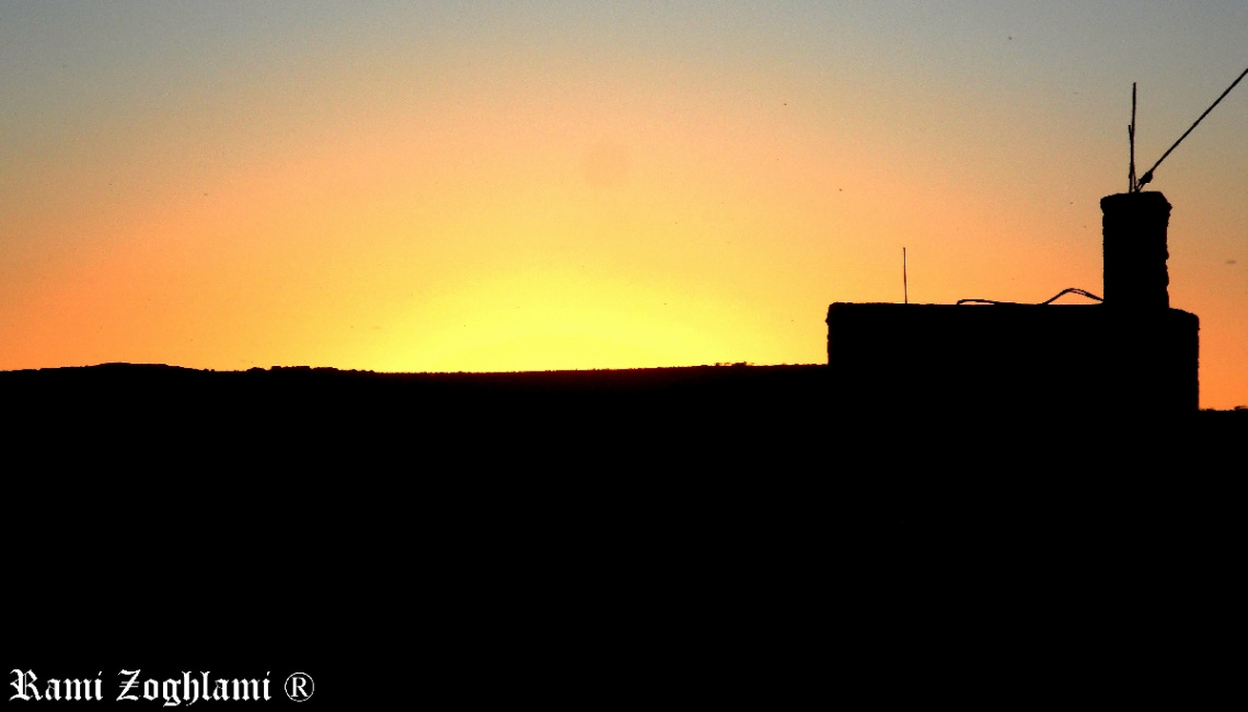 Sunset beyond a country house